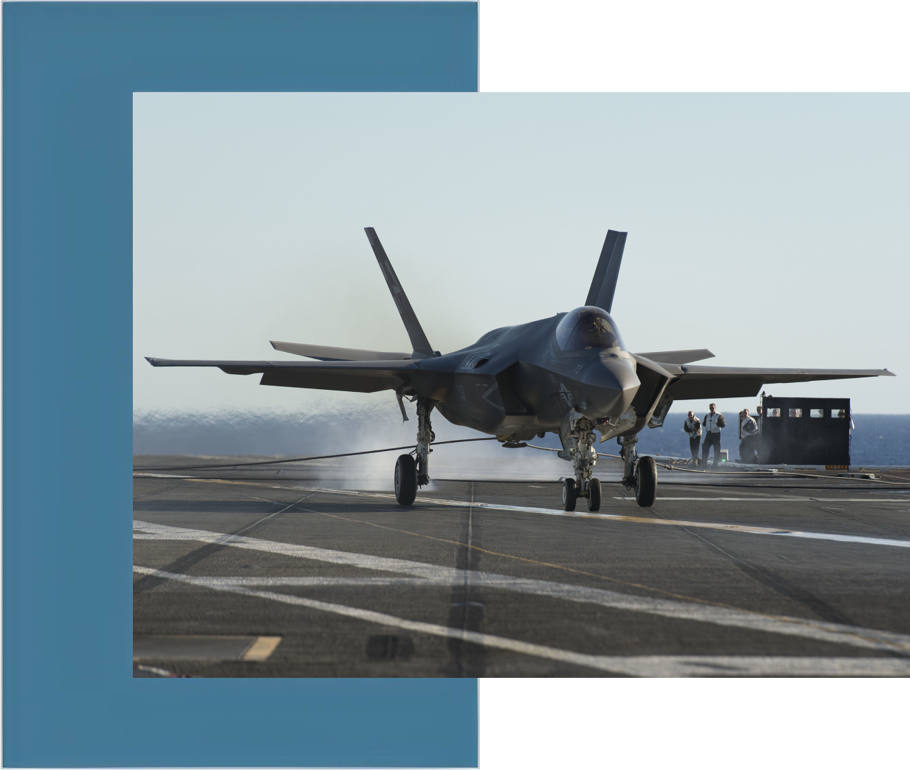 A fighter jet is on the runway of an aircraft carrier.