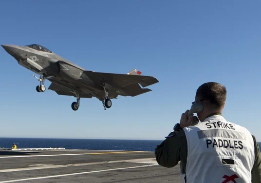 A man on the deck of an aircraft carrier.